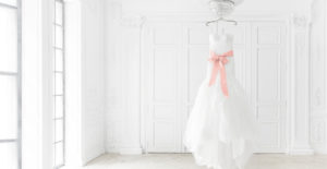 Wedding dress hanging in a white room